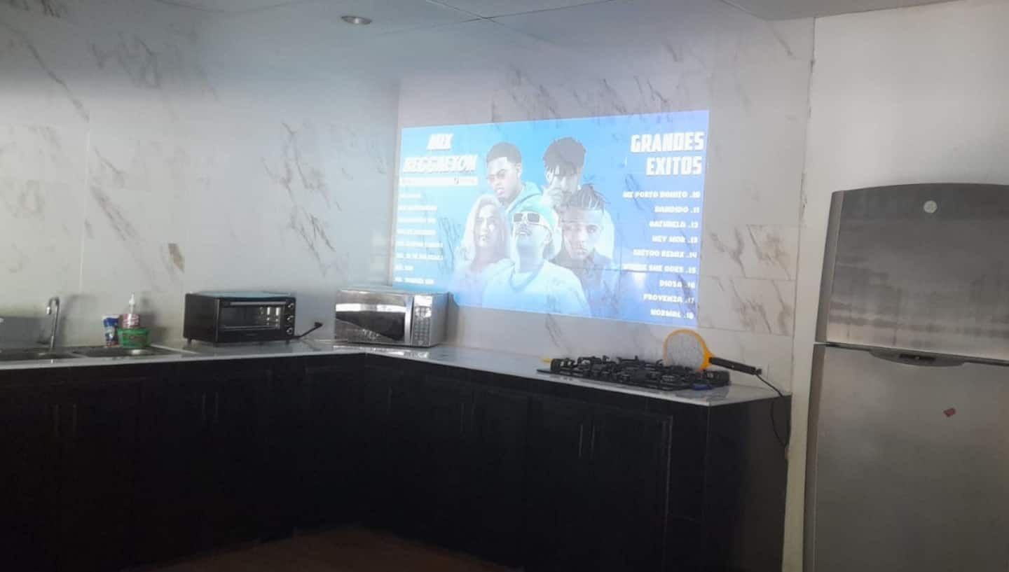 El Sunzal's projector throwing a karaoke menu onto the wall above the kitchen counter